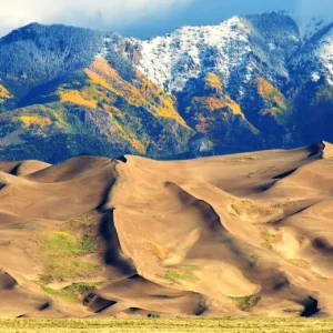 Find where sand meets snow tipped mountains