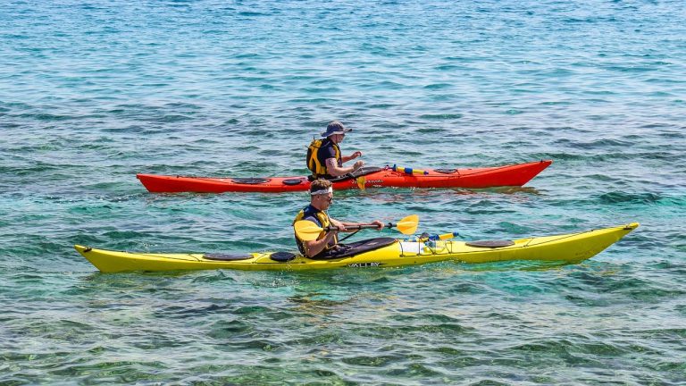 Two kayakers paddle while sea kayaking in Massachusetts.