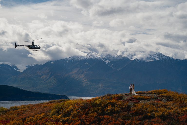 Helicopter flying over fall Alaska landscape in wedding photos
