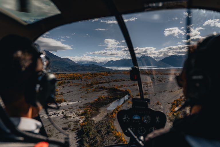 Looking at alaska landscape from behind helicopter pilot