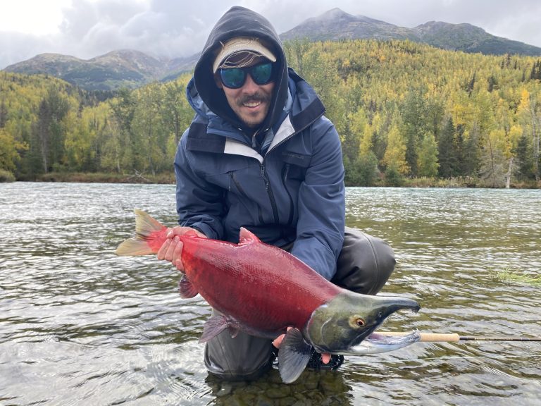 man catches salmon while fishing in alaska on kenai peninsula