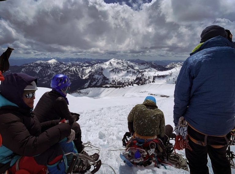 backpacking group overlooking mountain views on climbing tour