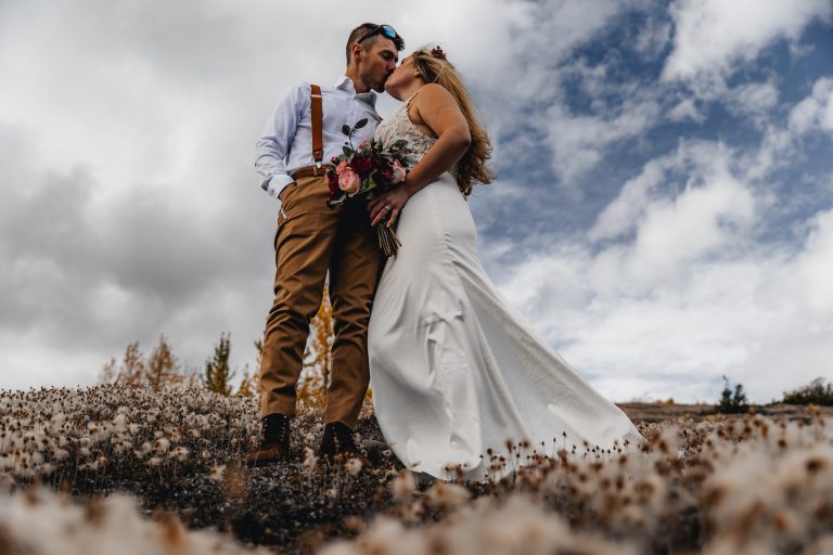 alaska elopement photos of couple kissing in a field