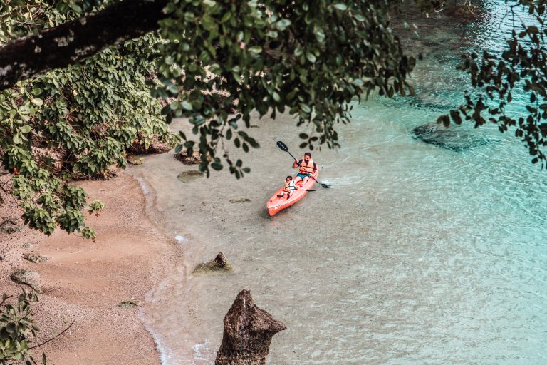 father and son kayaking in clear blue water