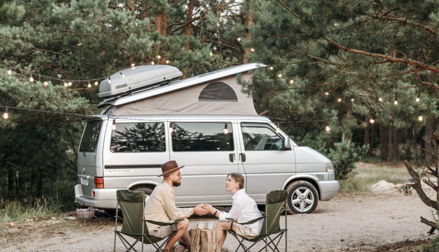 couple sipping coffee by campervan on vacation